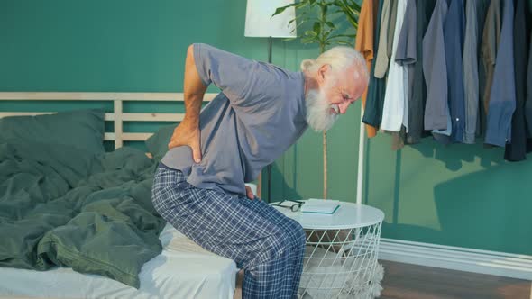 An Elderly Man Feels a Sharp Back Pain After Waking Up Poor Sleep Conditions alt