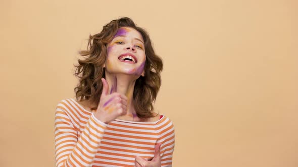 Portrait of Smiling Funny Woman with Multicolored Art on Her Face Suddenly Appearing on Camera and alt