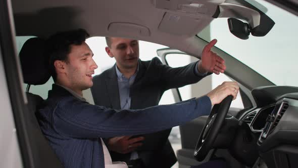 Successful Happy Male Customer Inspecting New Car Together with Auto Dealer in Automobile Sales