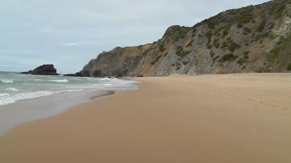Beach Filled with Footprints on Sand in Gruta da Adraga
