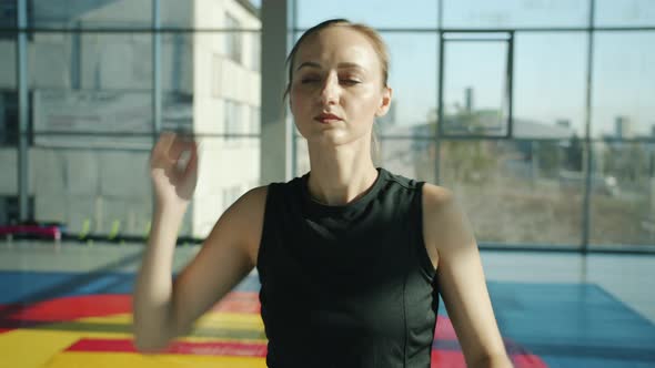 Portrait of Young Sportswoman Stretching Neck and Arms Doing Warmup Exercises in Modern Gym alt