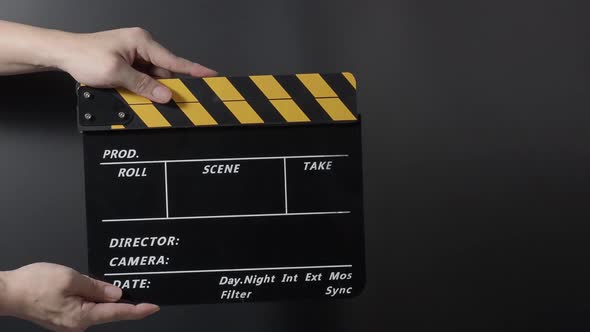 Movie clapperboard footage. Man hand holding film slate and clapping it in studio before shooting