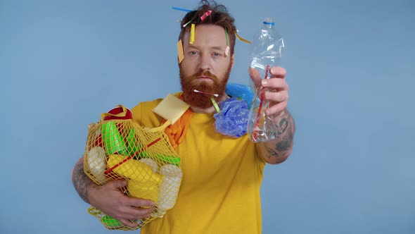 Man holding package with trash and crumpling plastic bottle. 