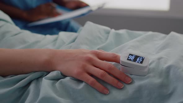 Close Up of Hospitalized Woman with Finger Heart Rate Monitor Showing Pulse alt