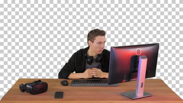 Serious gamer sitting at computer watching a game, Alpha Channel alt