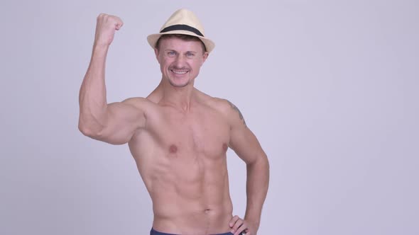 Happy Muscular Bearded Tourist Man with Fists Raised Shirtless alt