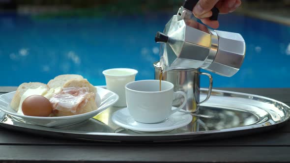 Man Pours a Coffee into the Cup