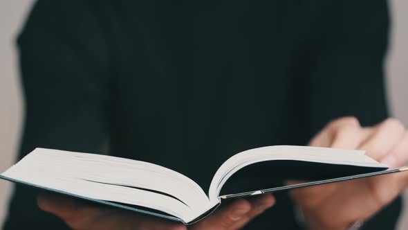 Young Man Reading a Book and Turning Pages Close Up Slow Motion alt