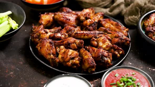Grilled Chicken Wings on a Black Plate on a Dark Rustic Background
