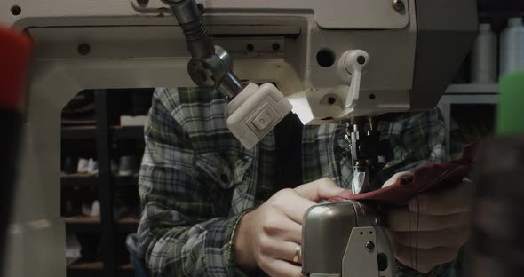 Tailor Works on Sewing Machine in Private Leather Craftshop Making Shoes in Process