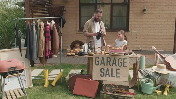 Father and Daughter Having Garage Sale in Summer alt