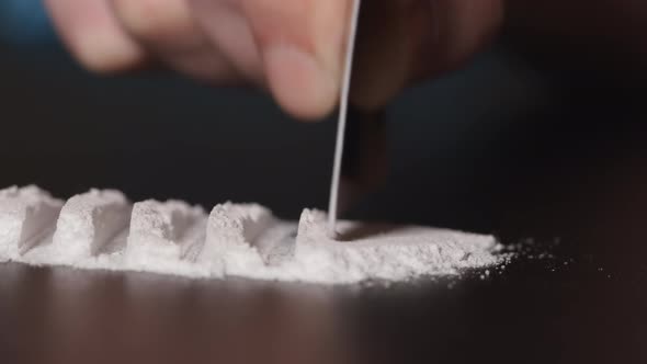 DRUGS: Man does a lines of heroin by plastic card - Close up