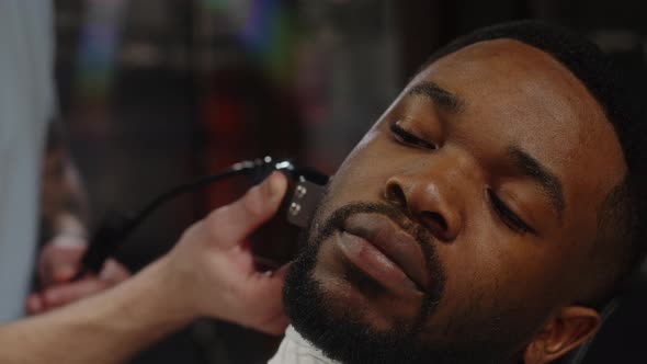 Professional Hairdresser Doing Beard Trim to Attractive Dark Skinned African American Guy alt