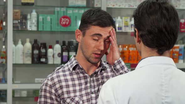 Attractive Young Man Shopping for Headache Medications alt
