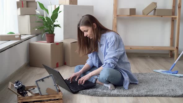 Moving Concept Happy Caucasian Couple Renters or Apartment Owners Young Woman Sitting on Floor Using alt