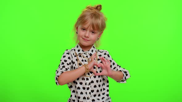 Smiling Child Girl Makes Heart Gesture Demonstrates Love Sign Expresses Good Feelings and Sympathy alt
