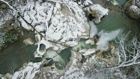 Waterfall Flowing From White Rocks Into a Lake in the Forest alt