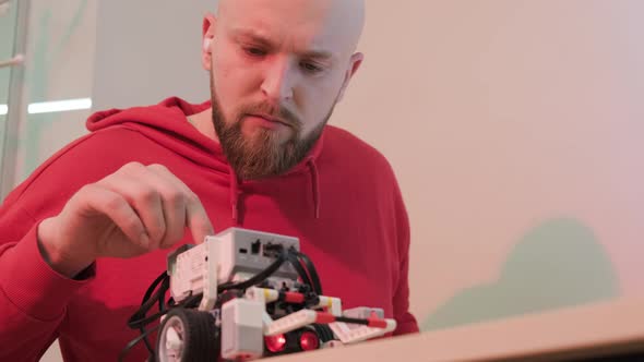 Close Up of a Robotics Teacher Hands Online Course for His Students Using a Robot alt
