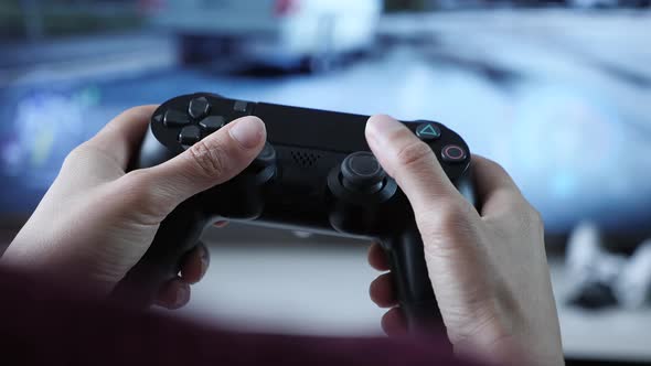 Hands holding controller, pressing buttons on game joystick and playing TV game alt