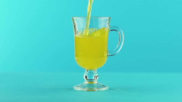 Slow Motion Close-up Shot of Fruit Fizzy Orange Soda Cold Beverage Drink Pooring Into Latte Glass alt