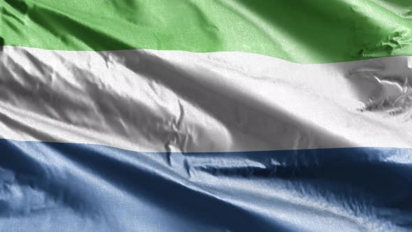 Sierra Leone flag waving on the wind. Slow motion. 20 seconds loop.  alt