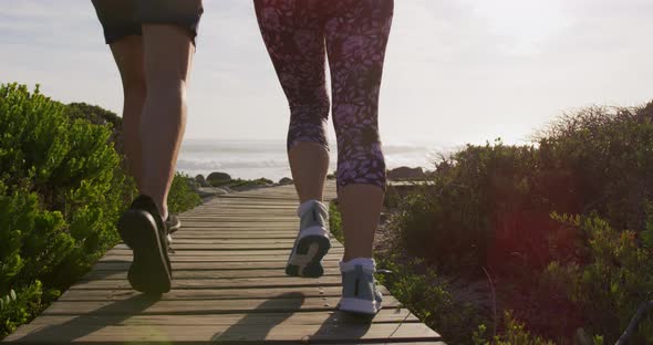 Caucasian couple enjoying free time by sea on sunny day running path alt