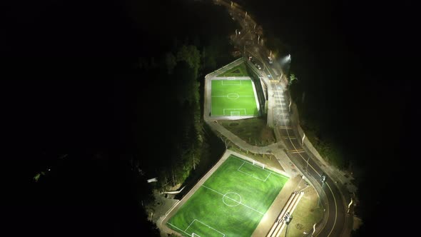 Aerial Cinematic Drone View of a Lit Soccer Field at Night