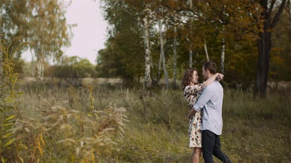 Young Couple Walking on a Meadow alt