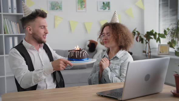 Holiday Online Smiling Girl Has Fun with Husband and Blows Out Candles on Birthday Cake During Gala alt