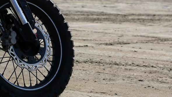 Close-up of a motorcycle wheel on a sandy beach. 4K motorcycle video