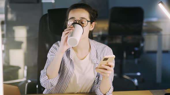 Young Woman Use Phone at Table in Office