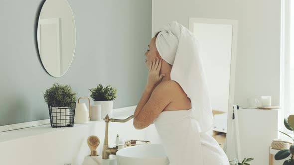 Happy woman uses cosmetics for skin and body care alt