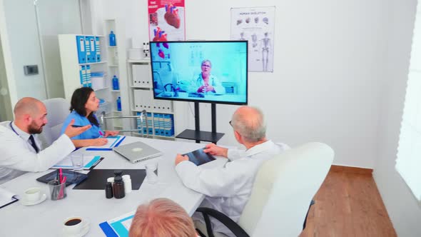 Team of Medical Staff During Video Conference with Doctor in Hospital alt