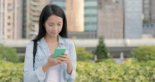 Woman working on mobile phone at street alt