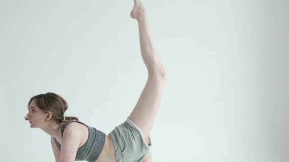 Slim Girl in Sportswear Practice Yoga Cat Cow Pose on White Cyclorama Background alt