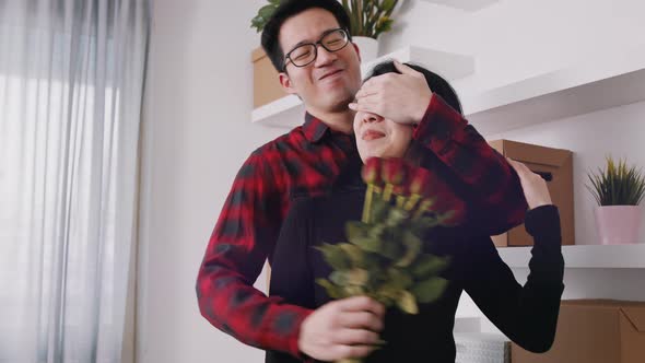 Young Man Closing Eyes of His Girlfriend with Hand and Gifting Her with Bouquet of Red Roses  alt