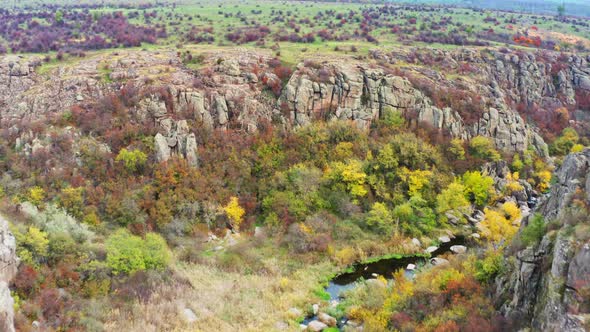 A Picturesque Stream Flows in the Aktovsky Canyon Surrounded By Autumn Trees and Large Stone alt