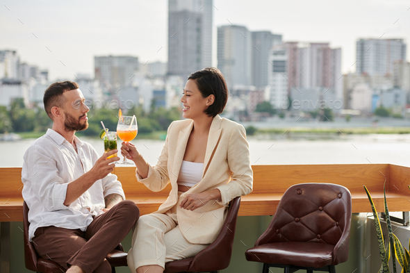 Couple Enjoying Refreshing Drinks at Rooftop Bar