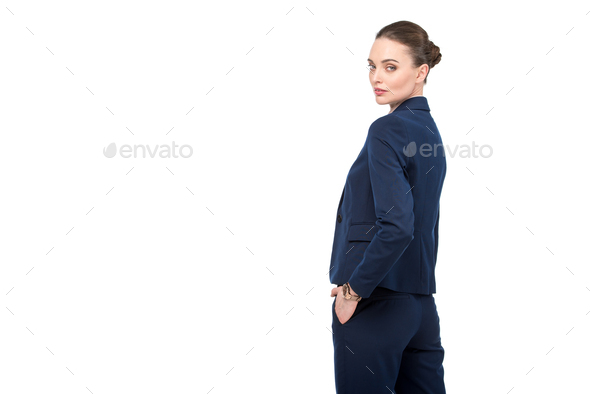 stylish adult businesswoman turning back and looking at camera isolated on white