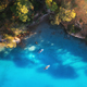 Aerial view of floating board and people on blue sea, rocks - PhotoDune Item for Sale
