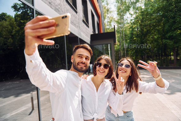 Making a selfie. Three friends having great weekend outdoors together