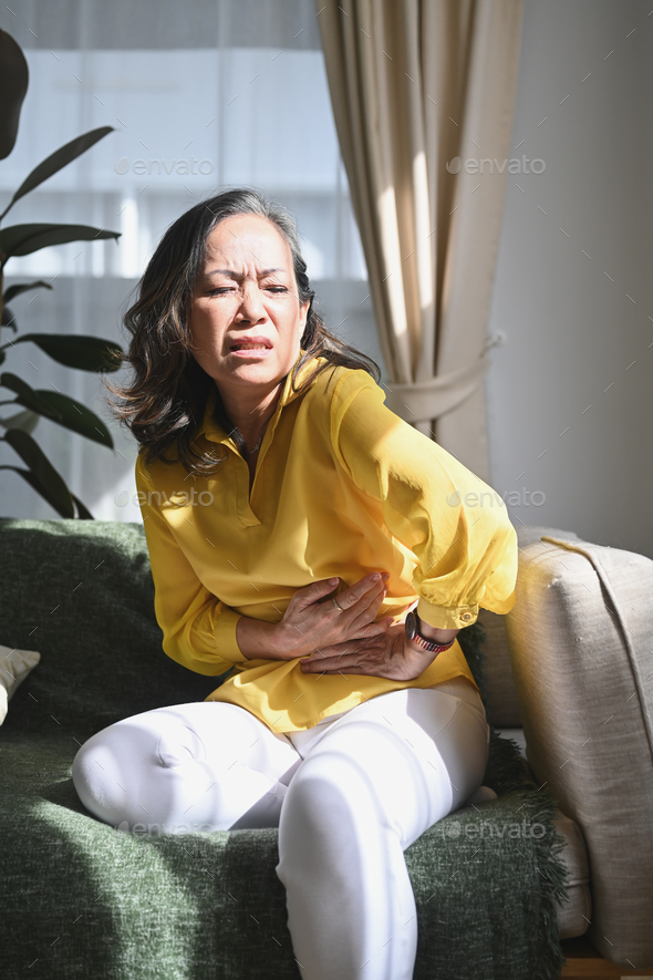 Upset mature woman suffering from abdomen ache, symptoms gastrointestinal system disease.