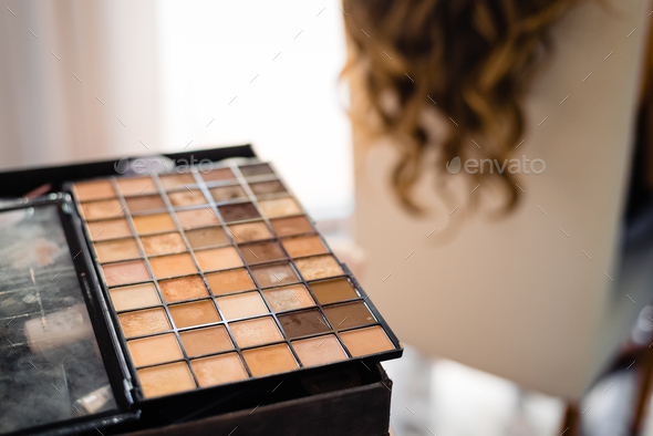 Professional makeup box with powders in ocher tones.