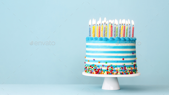 Striped buttercream birthday cake with colorful birthday candles and sprinkles - Stock Photo - Images
