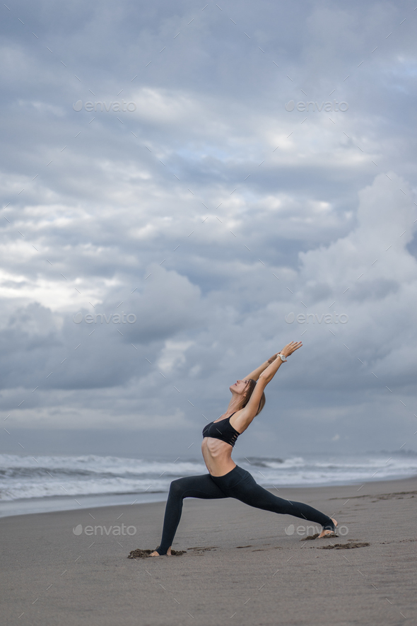 Side view of woman standing in warrior yoga pose. Stock Photo | Adobe Stock