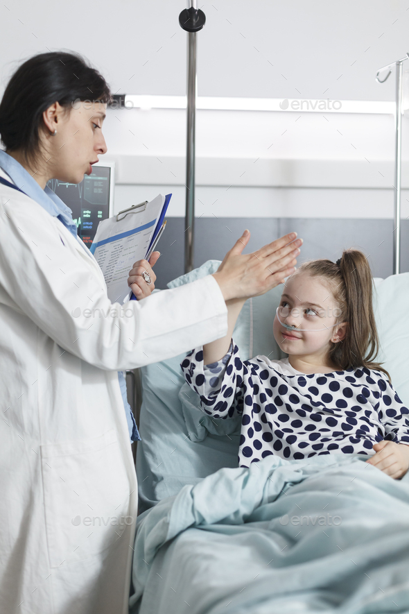 Happy cheerful young patient highfive pediatric expert while in medical examination room
