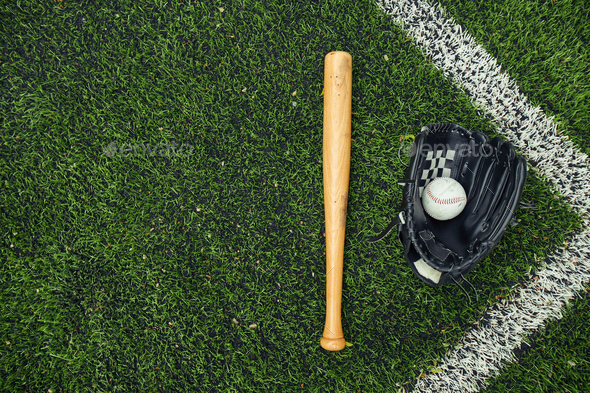 Old baseball glove and bat on field