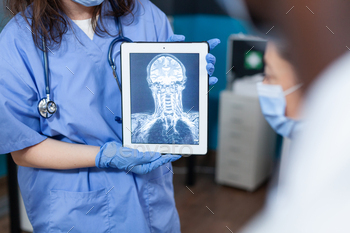 Closeup of therapist woman asisstant holding tablet computer with radiograpy