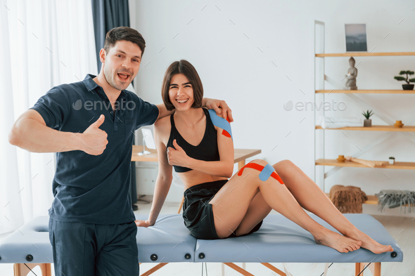 Finished result. Woman visiting physiologist that putting kinesio tape on the skin - Stock Photo - Images