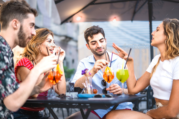 Four trendy young people get together carefree sitting and bonding at ...